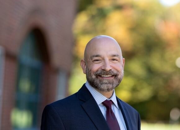 Eric Sykes smiles at the camera.