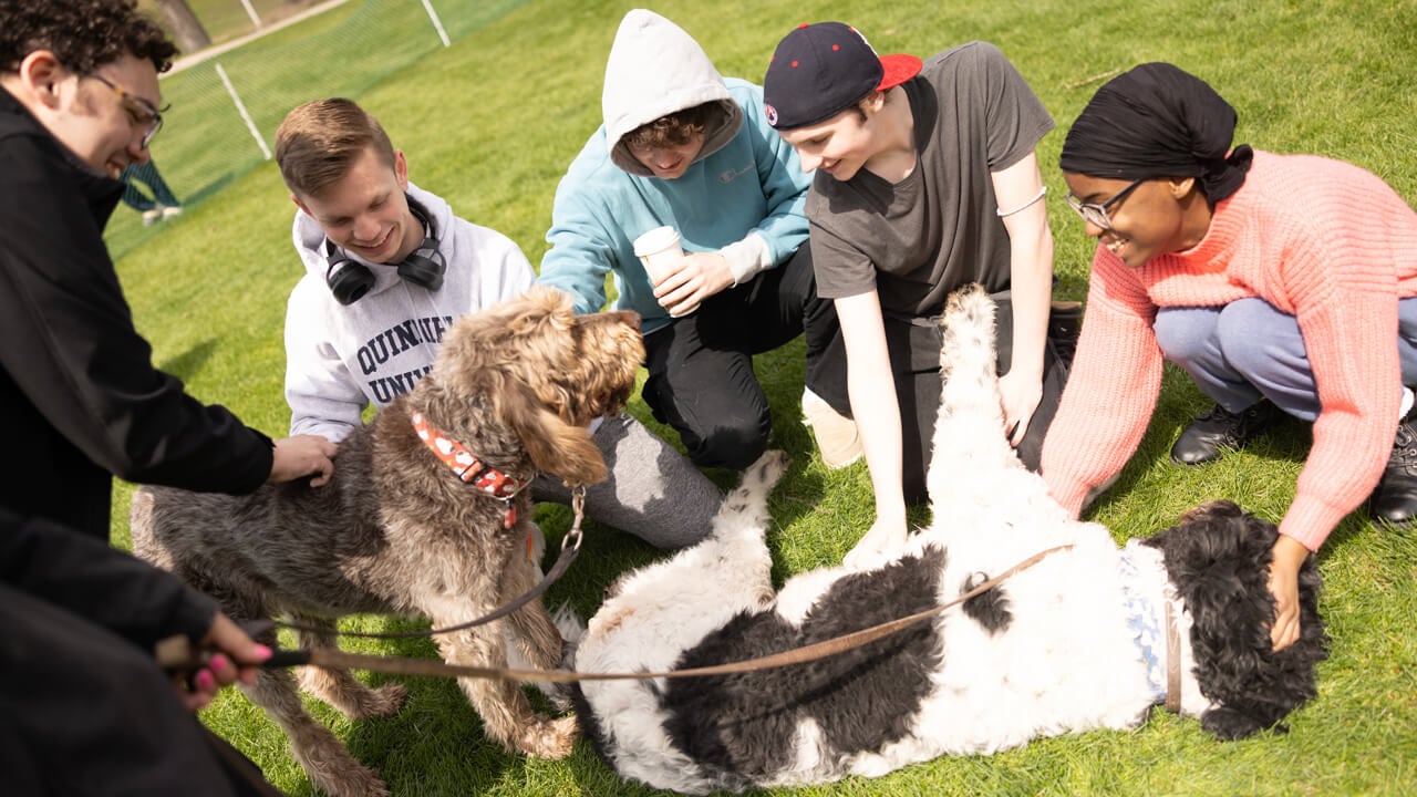 People smiling while petting a dog