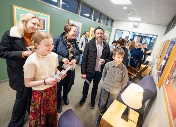 People look at the artwork displayed on the walls