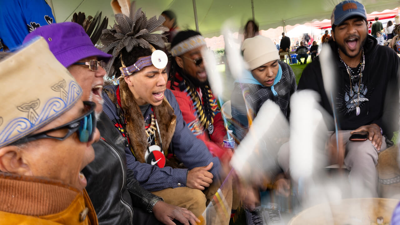 Group of people participating in the powwow