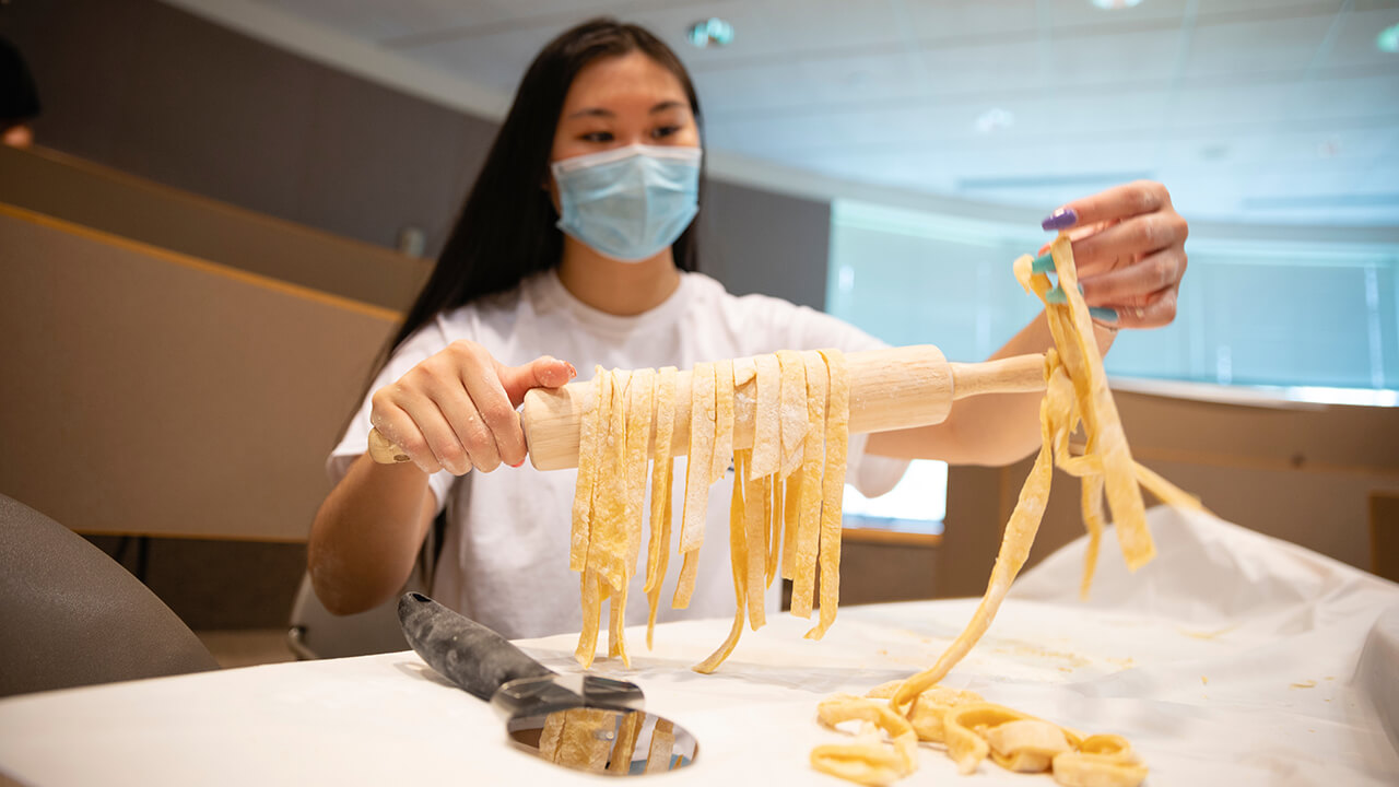 A student makes pasta.