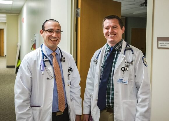 Sondheim stands with Birch in their white coats.