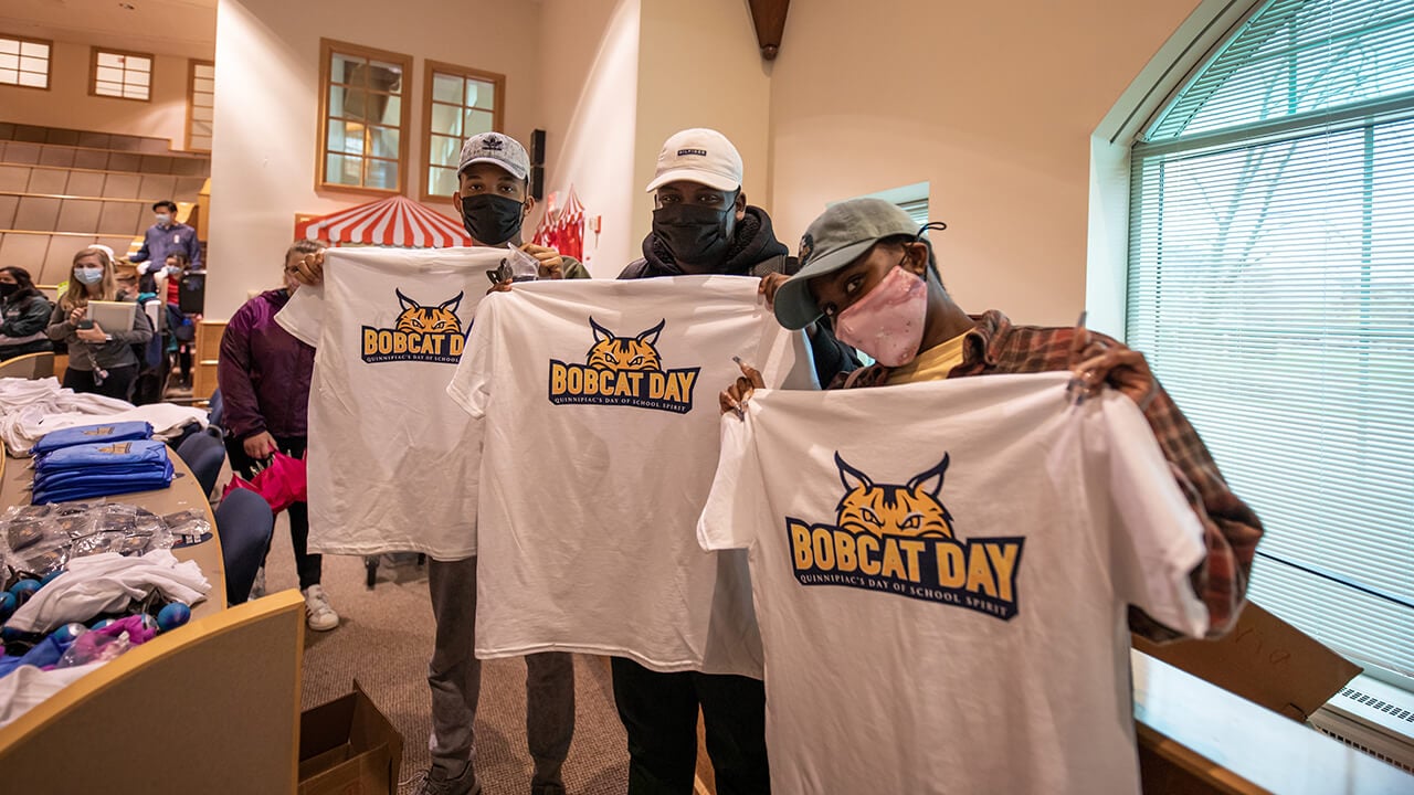 Students hold t-shirts at Bobcat Day.