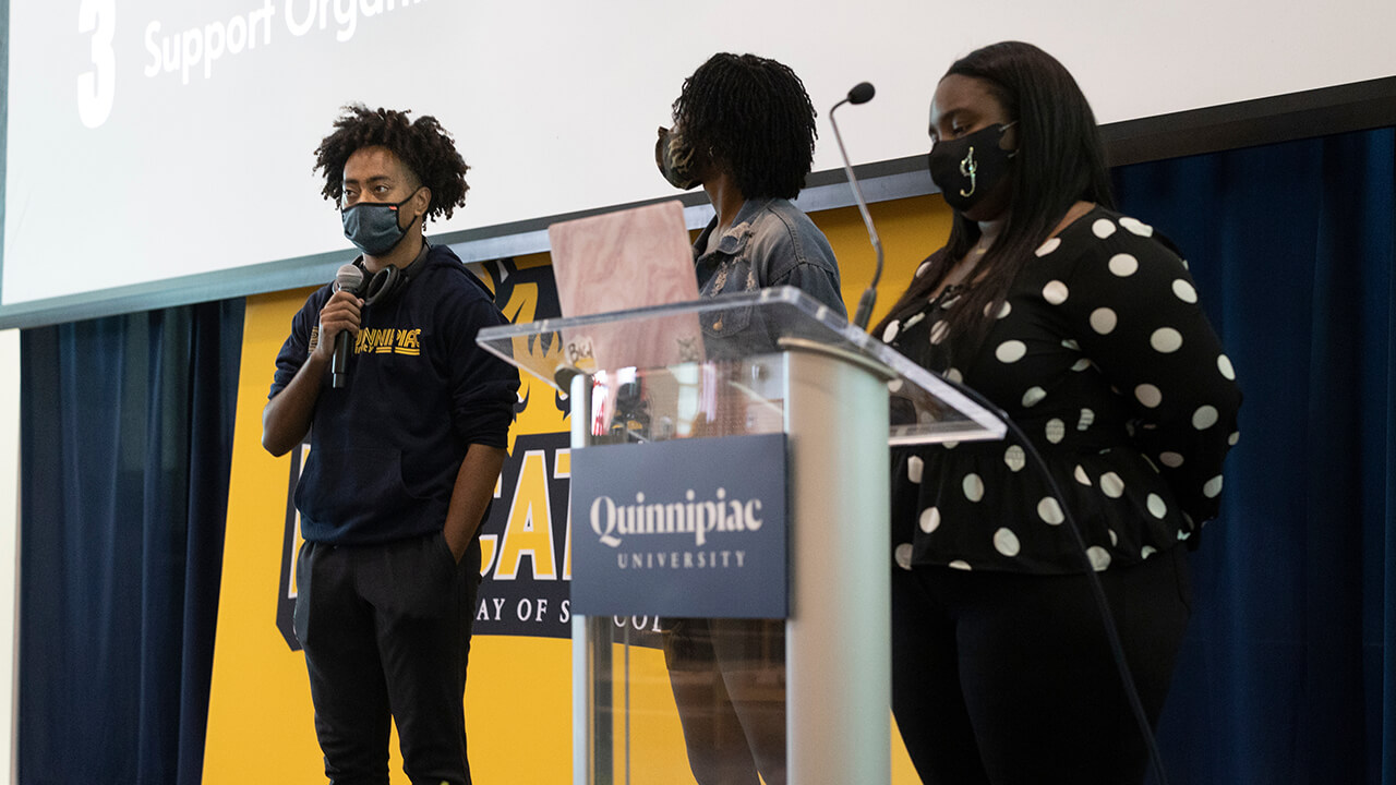 Students speak behind a podium as part of Bobcat Day.