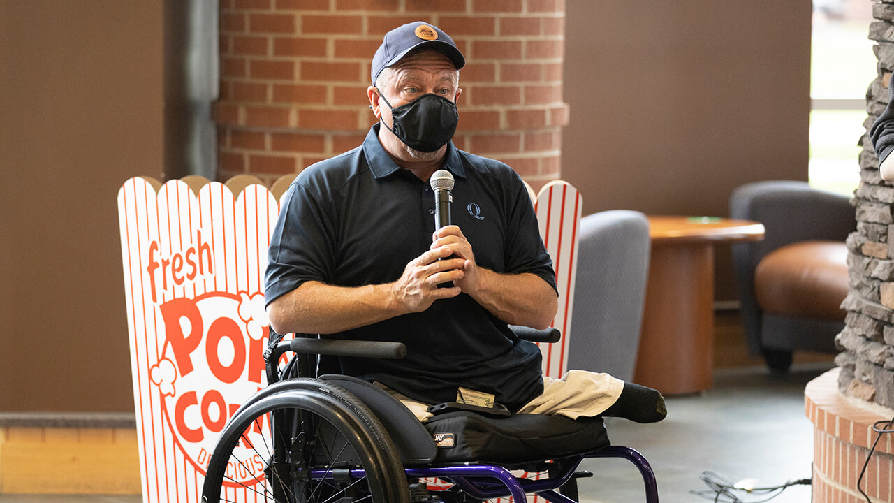 A person holds a microphone at Bobcat Day.
