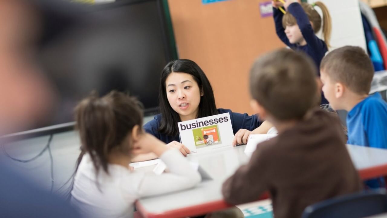 Monroe shares a book with students.