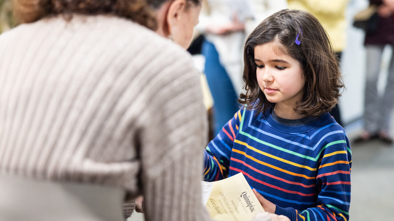 8-year-old Alicia Queralt, a Spring Glen School student, receives a certificate during the Kaleidoscope of Creativity event.