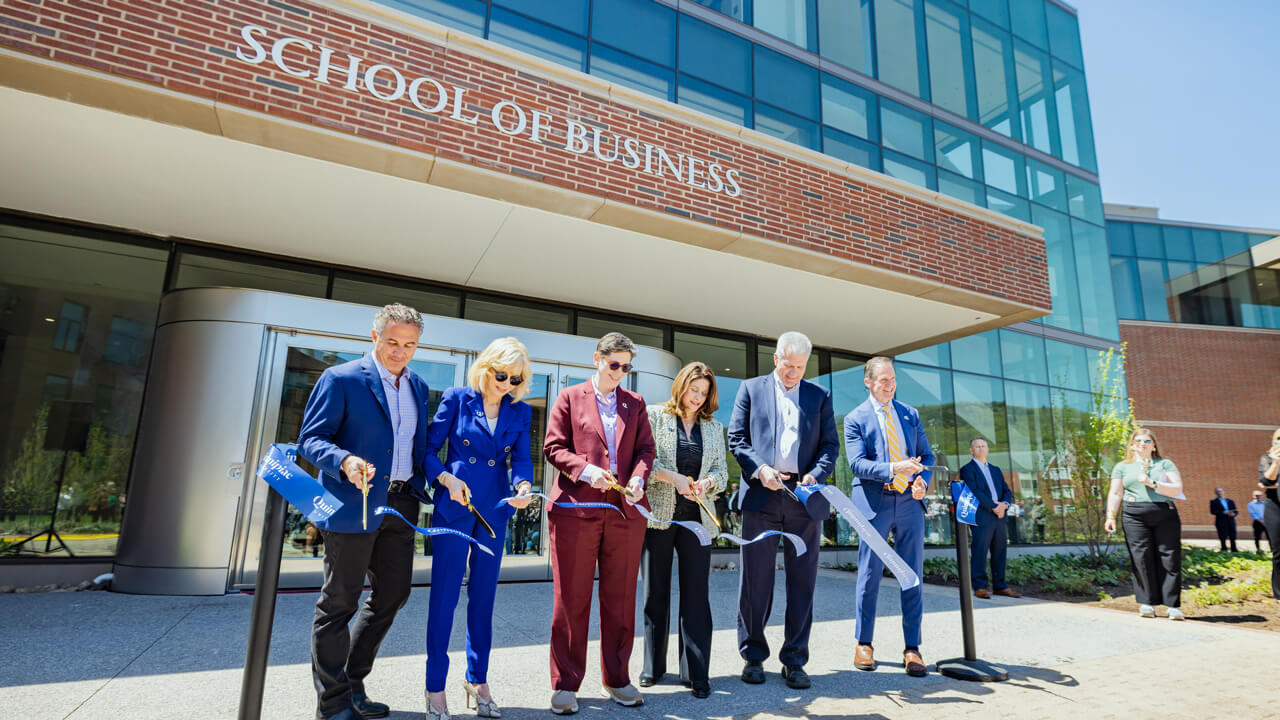 Group cuts the ribbon in front of the new School of Business