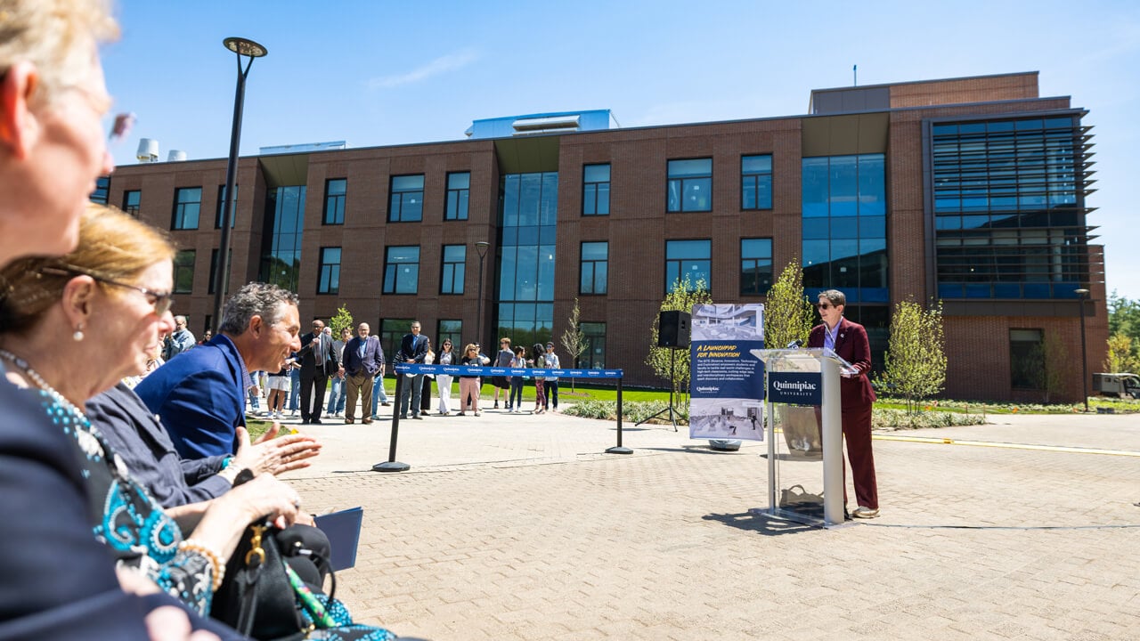 Wide shot of people speaking and sitting