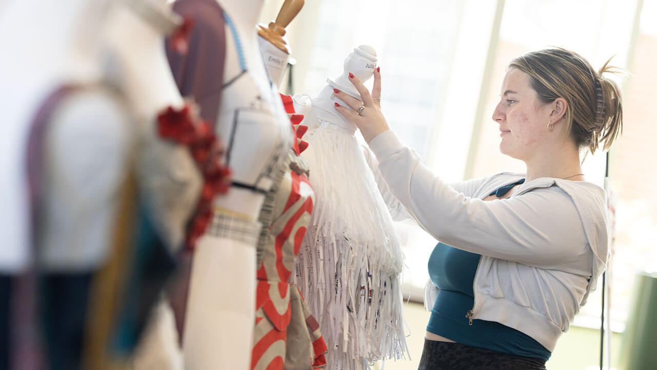 Student perfects her sustainable fashion piece at the Earth Day fair