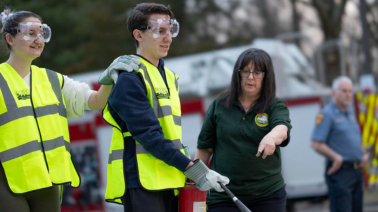 Hamden CERT member shows students how to properly extinguish a fire