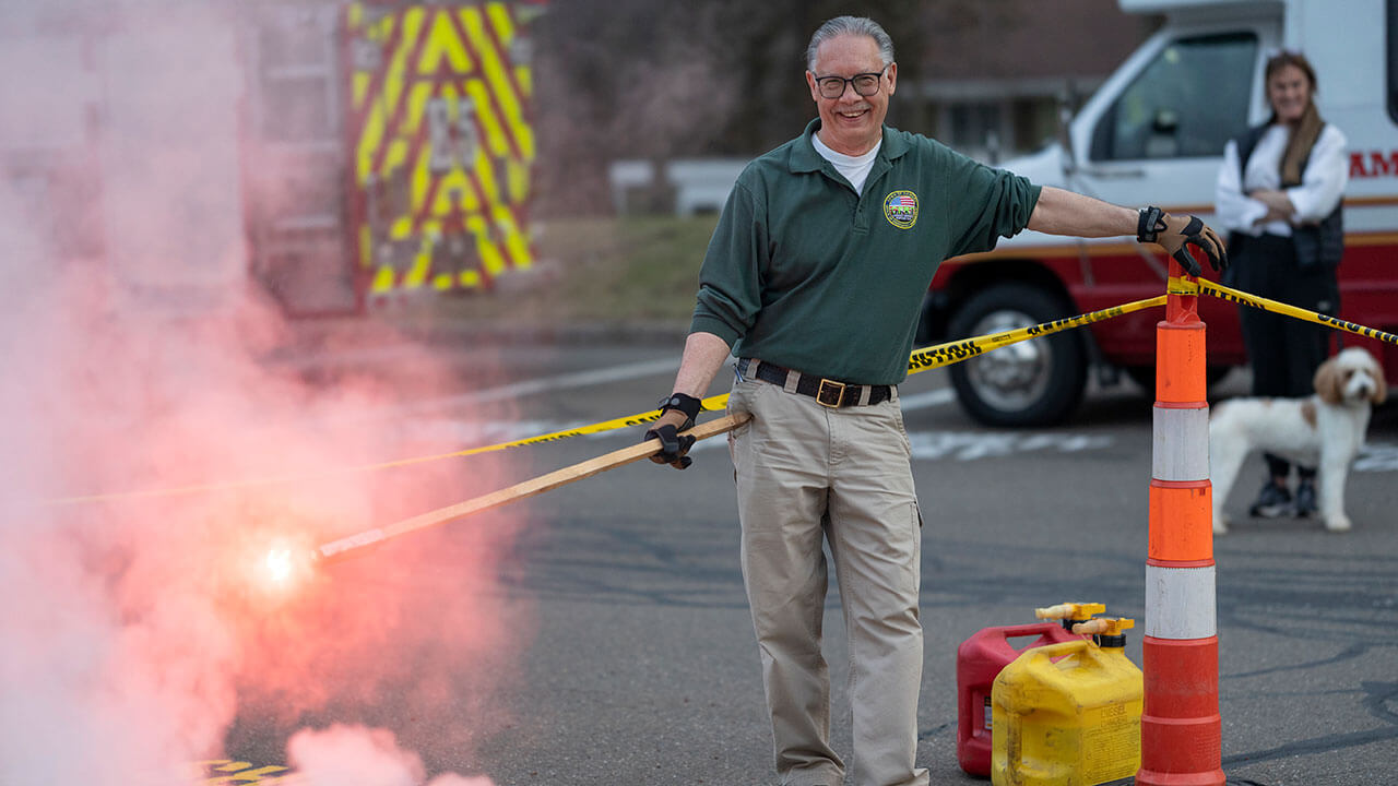 Hamden CERT member smiles next to fire