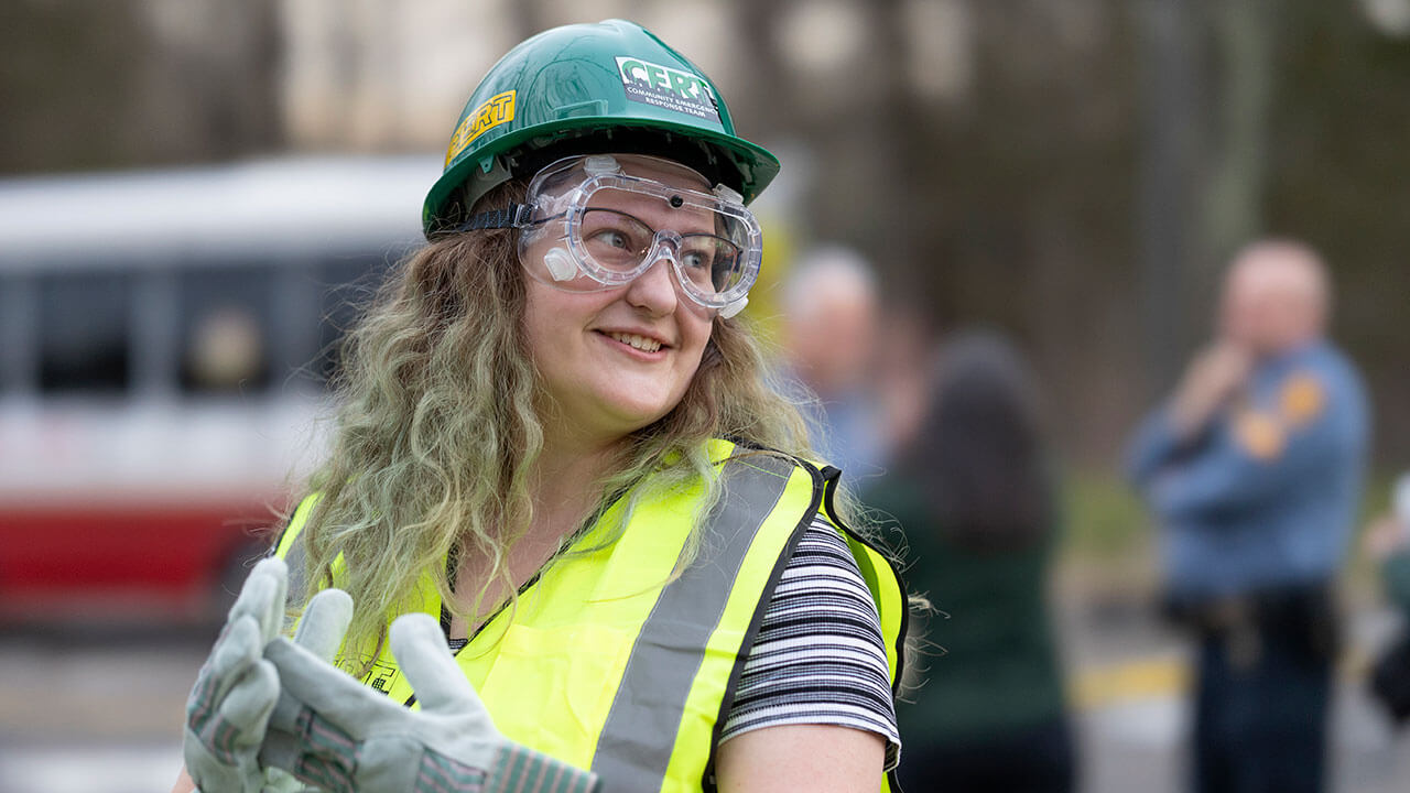 Student smiles with goggles and CERT gear on