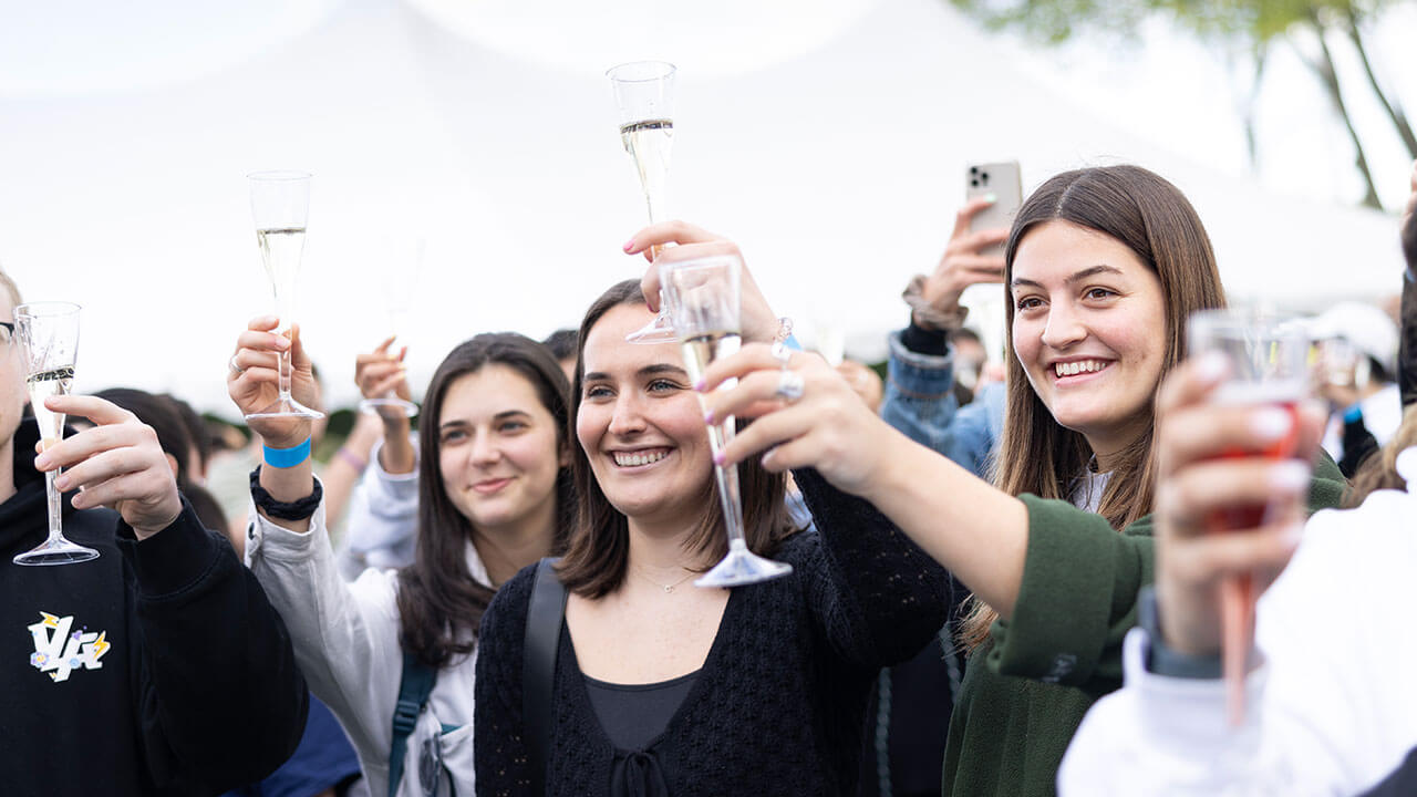 Students raise their glasses during a speech