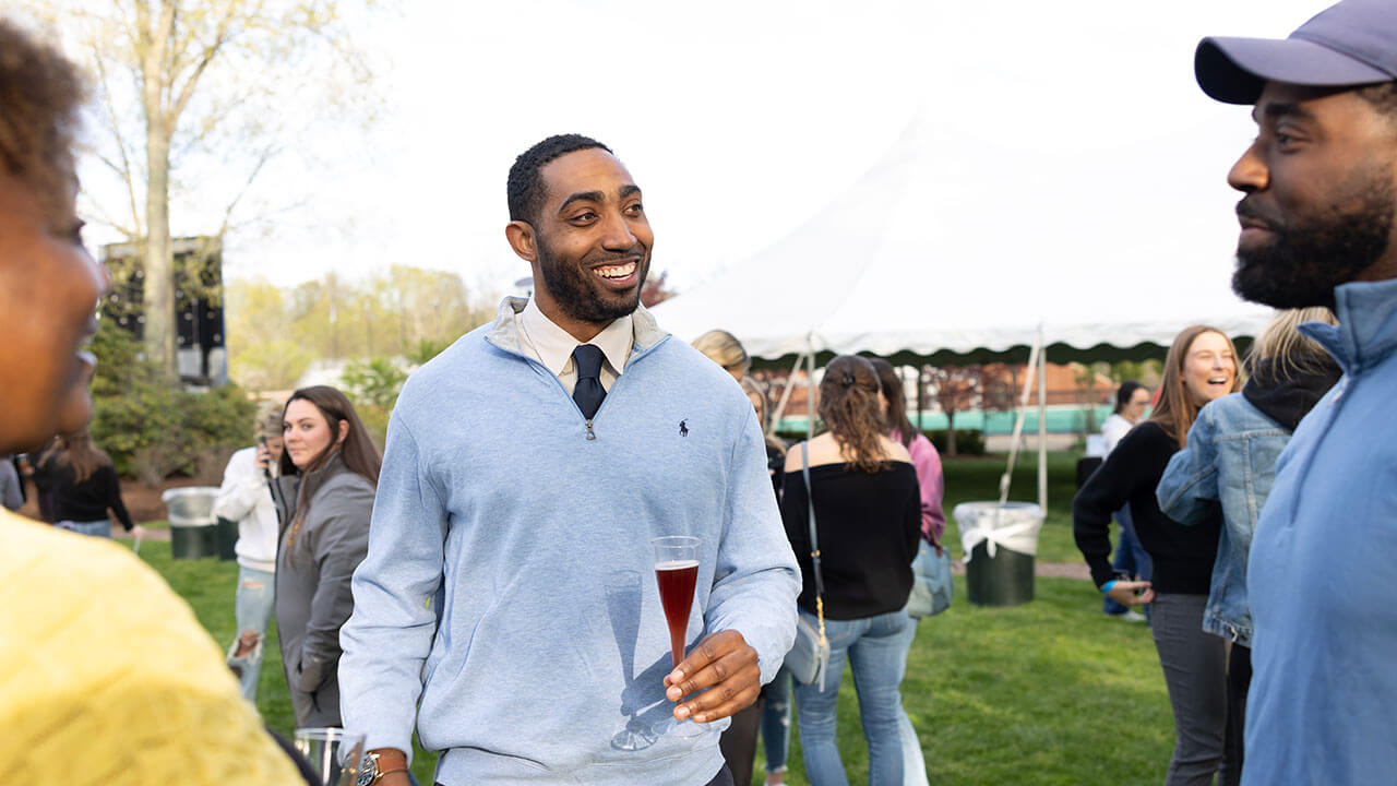 Student smiles with his glass in hand