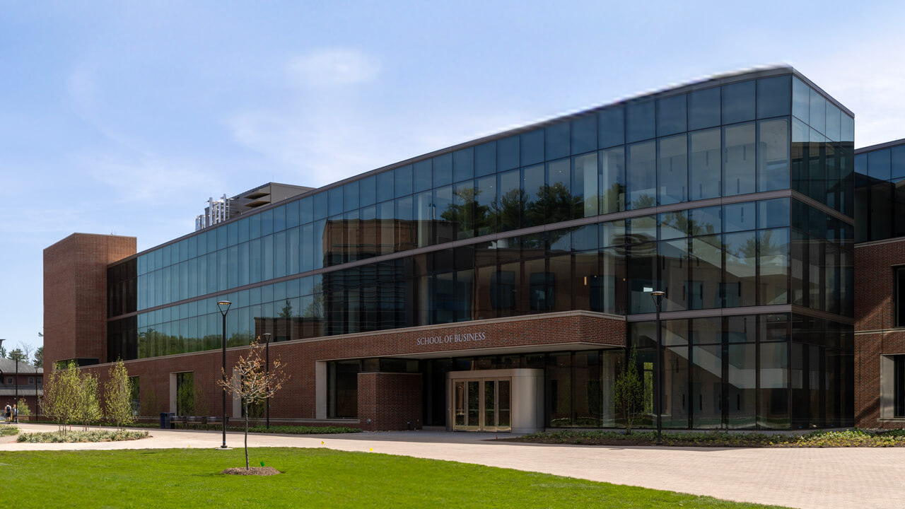 Exterior of the new School of Business gleaming with a wall of windows on a bright and sunny day