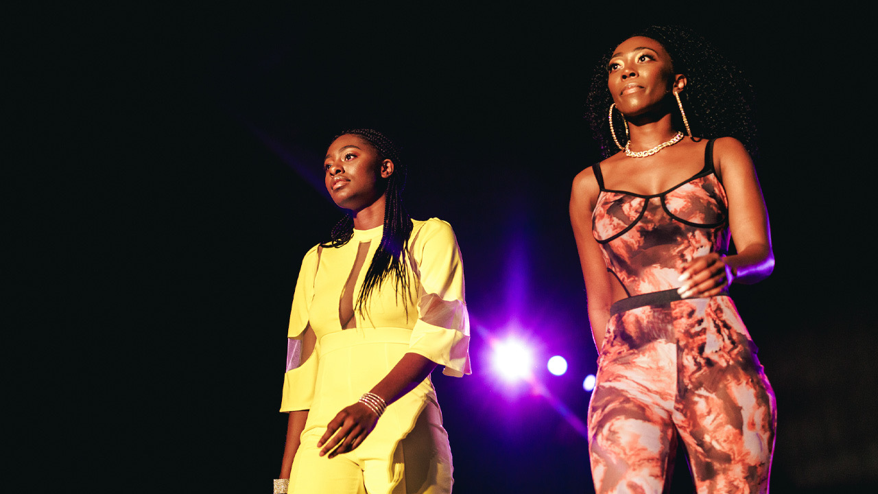 Girl in yellow dress and brown tie-dye dress walk the runway