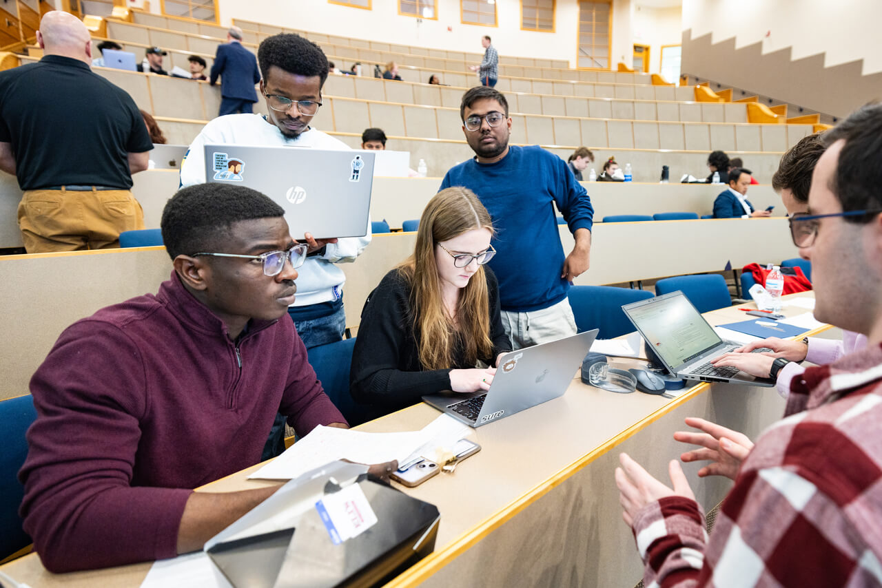Students working on computers in a collaborative group setting.
