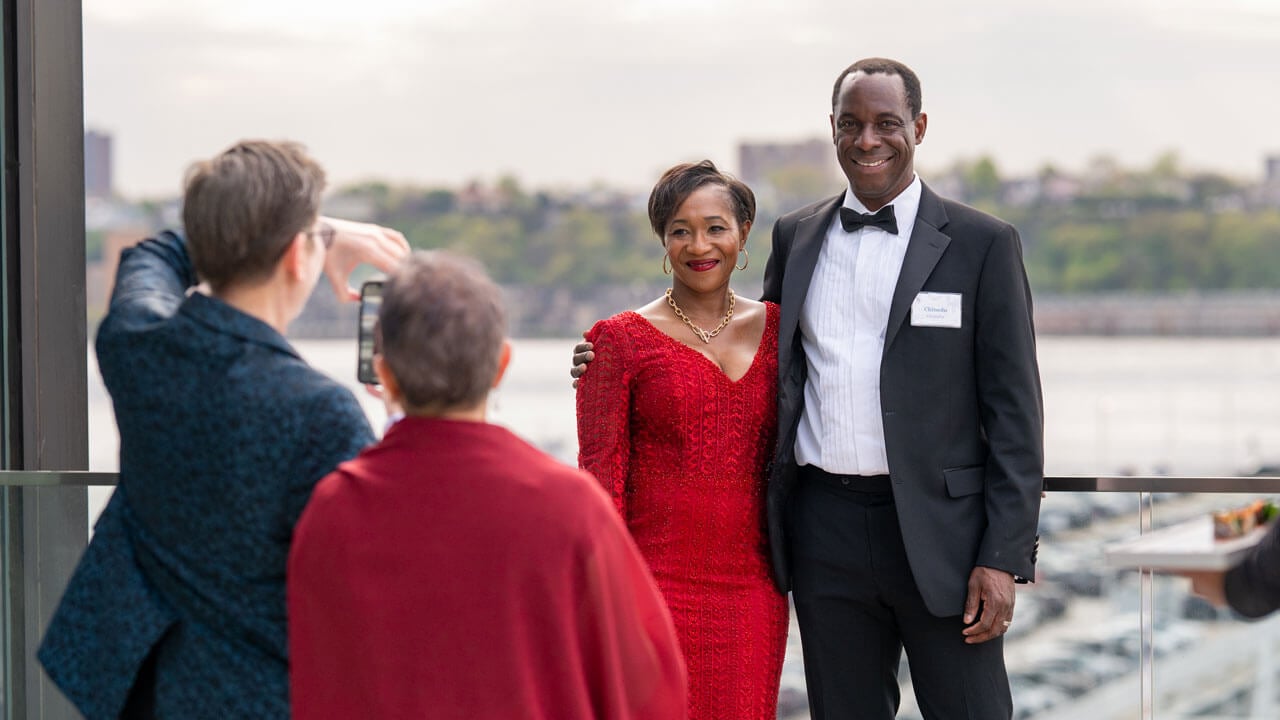 Photo of individuals taking a photo on an iPhone.