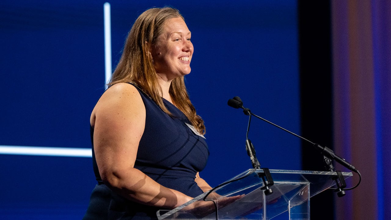 Speaker addresses the crowd at a podium.