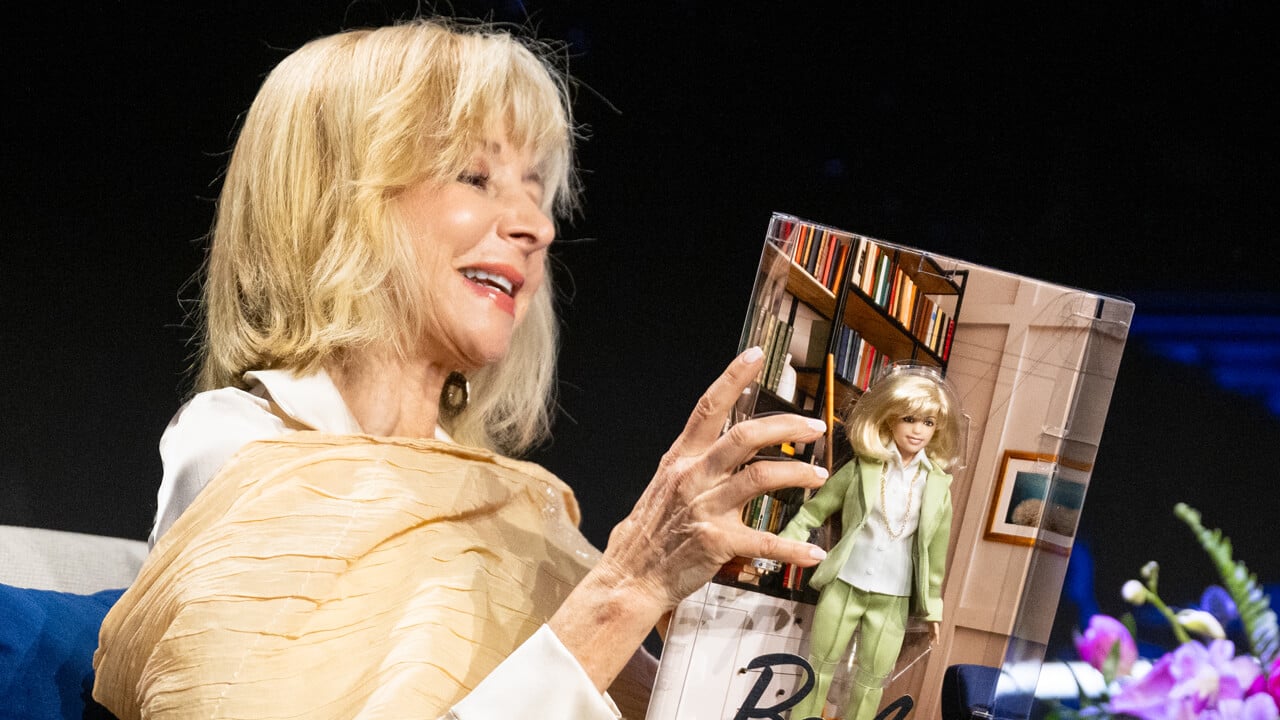 President Olian holds a Barbie doll