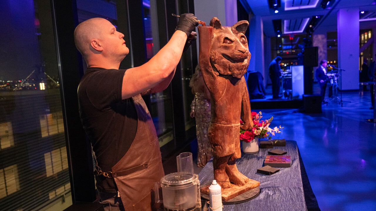 Person carving a chocolate bobcat