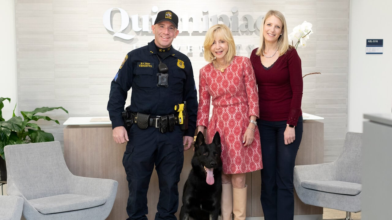 Judy Olian poses with a police dog