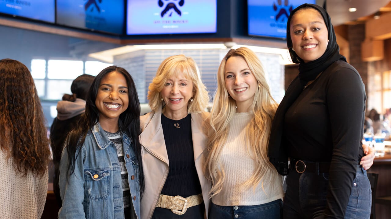Judy Olian poses for a photo with students