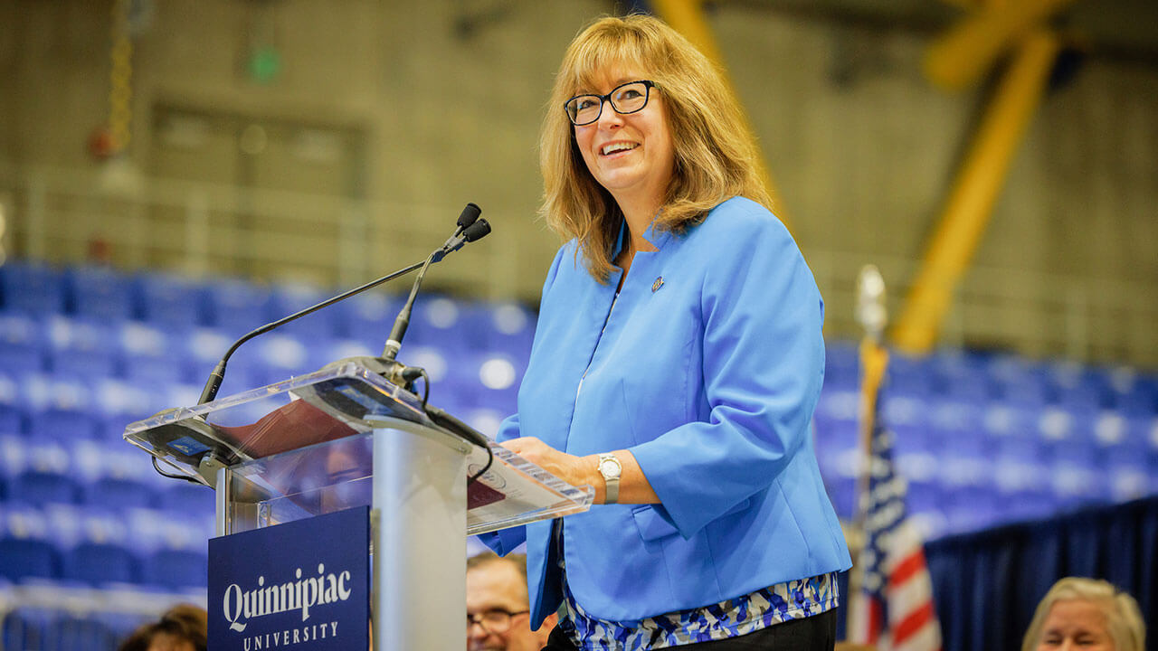 Dean of Nursing Lisa O'Connor stands behind a podium addressing the audience