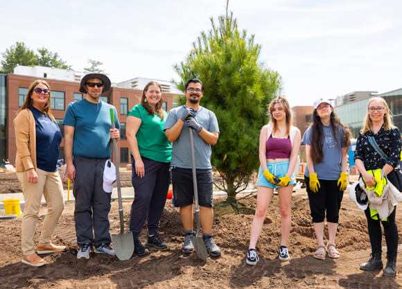 People pose with the newly planted tree