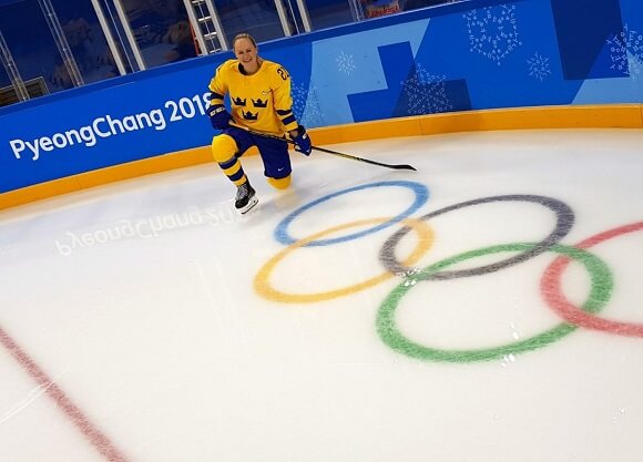 Udén Johansson kneels on the ice.