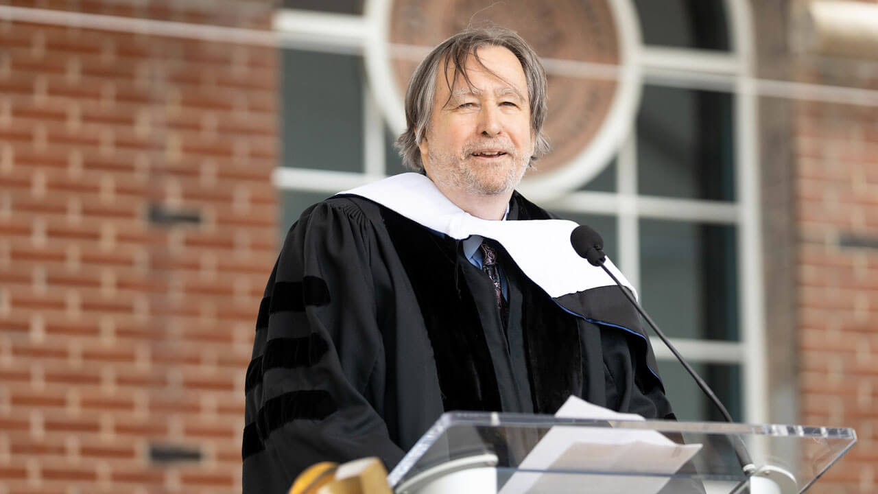 Cheyney Ryan speaks at the podium during Commencement