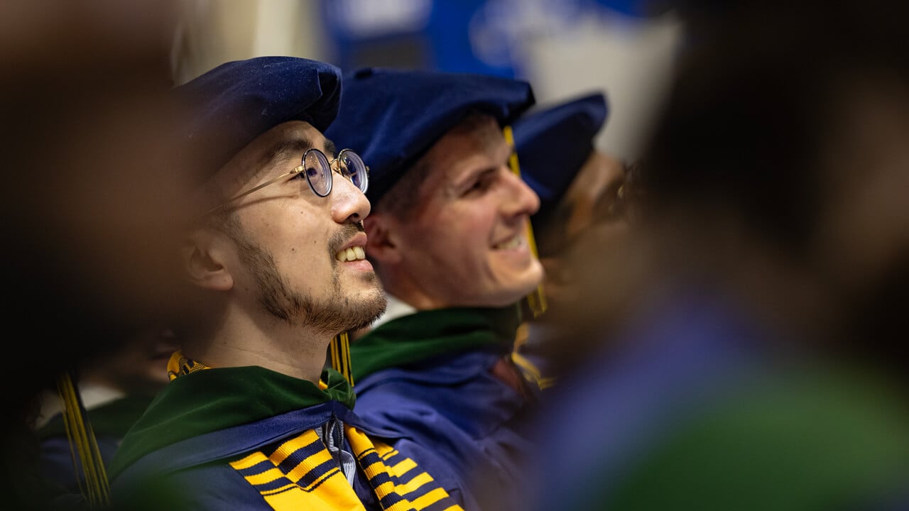 Two people sitting in the crowd smiling