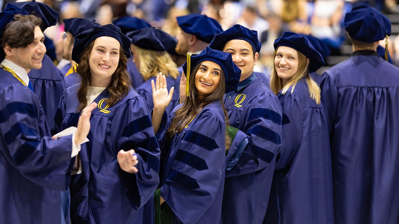 5 graduates turned around and waving with smiles