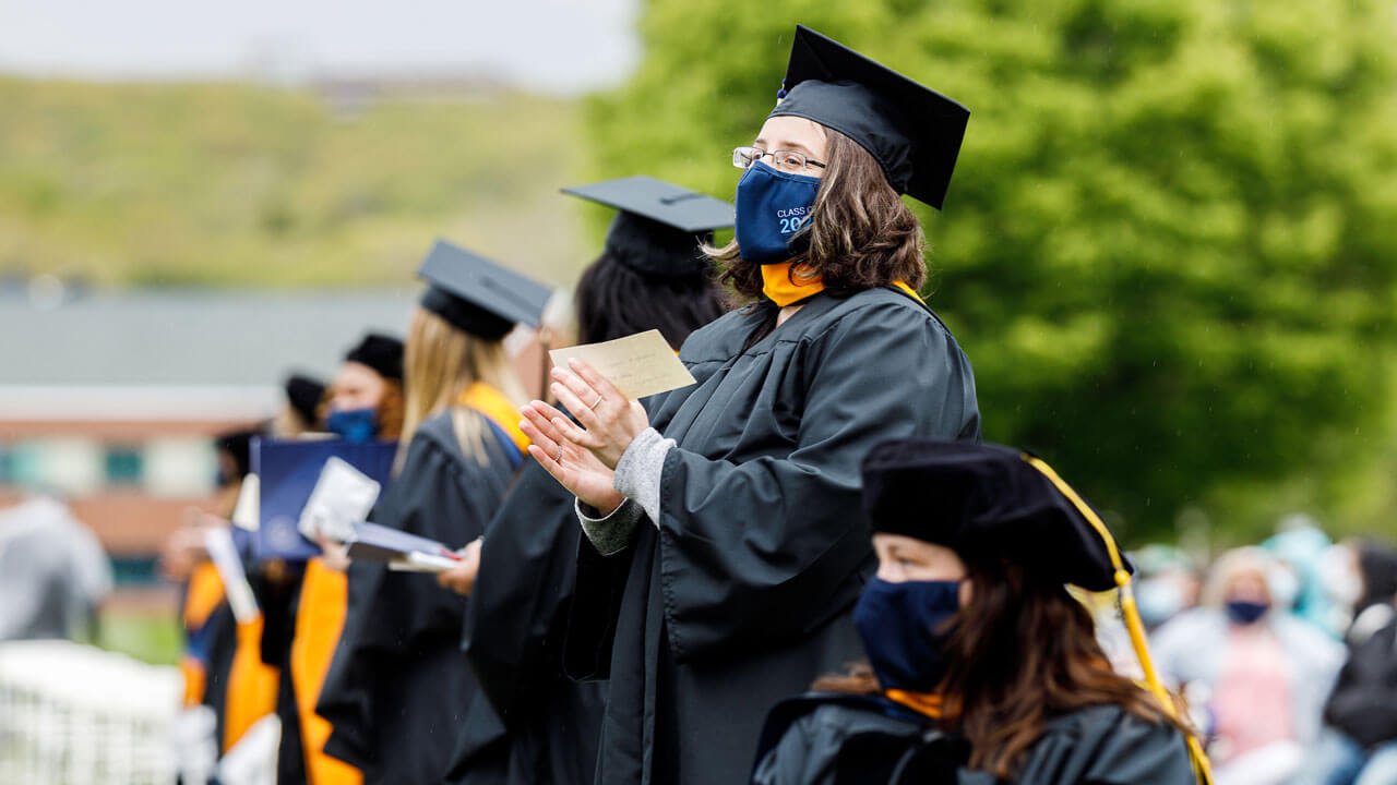 Student clapping and wearing class of 2021 mask