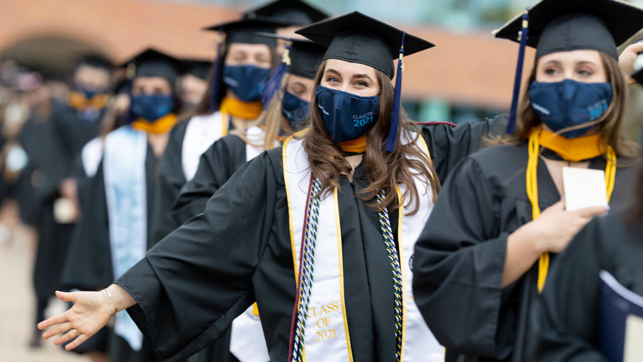 Several graduates celebrate in their caps and gowns