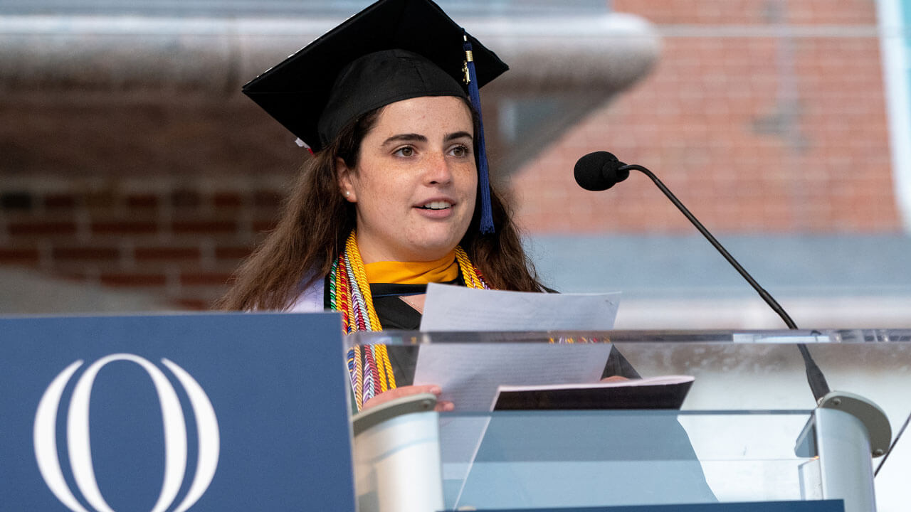 Morgan Literate speaks at the podium during Commencement