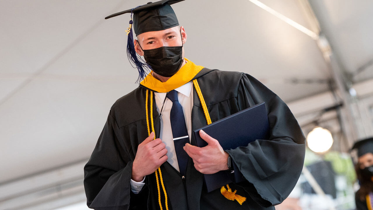 A graduate crosses the stage during Commencement