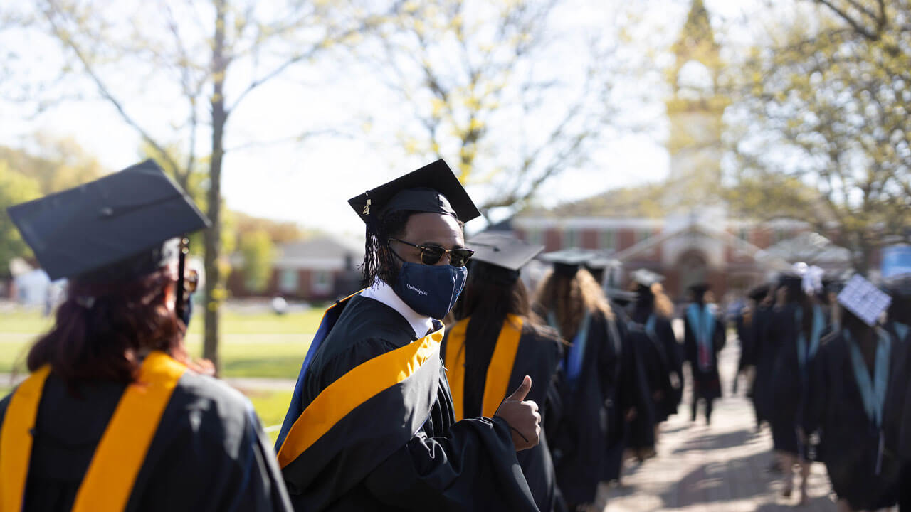Students lined up infront of library and student gives a thumbs up