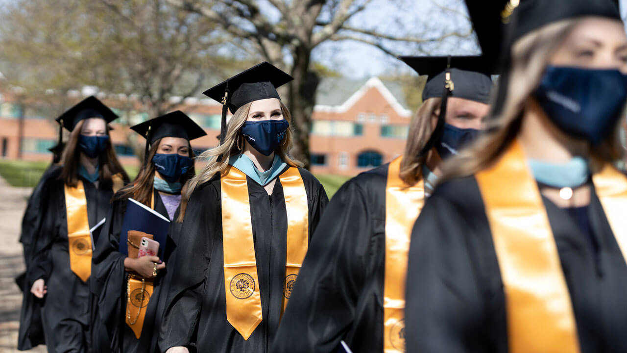 Girls wearing gold sashes and lined up