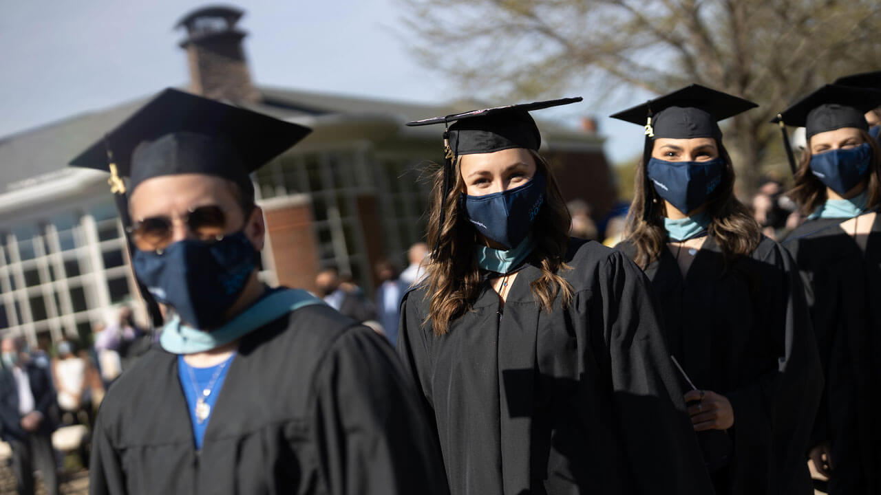 Students smiling while standing in line on quad