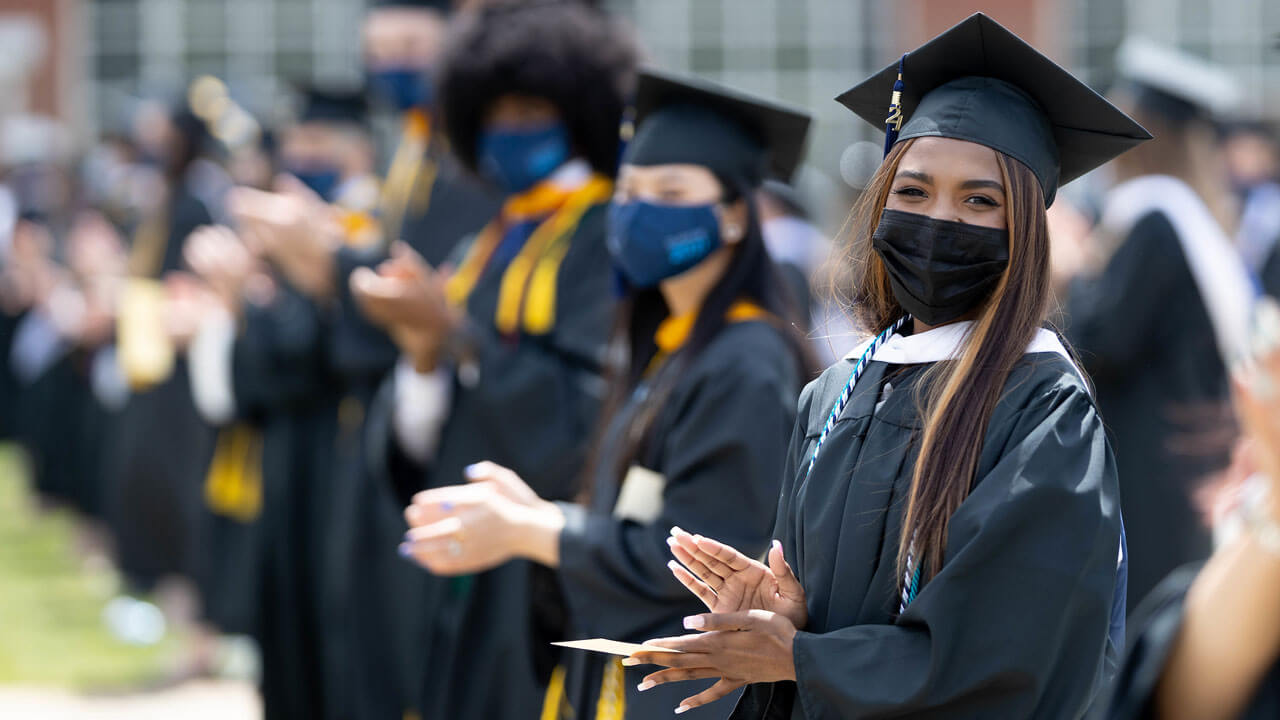 Students clapping at college of arts and sciences commencement