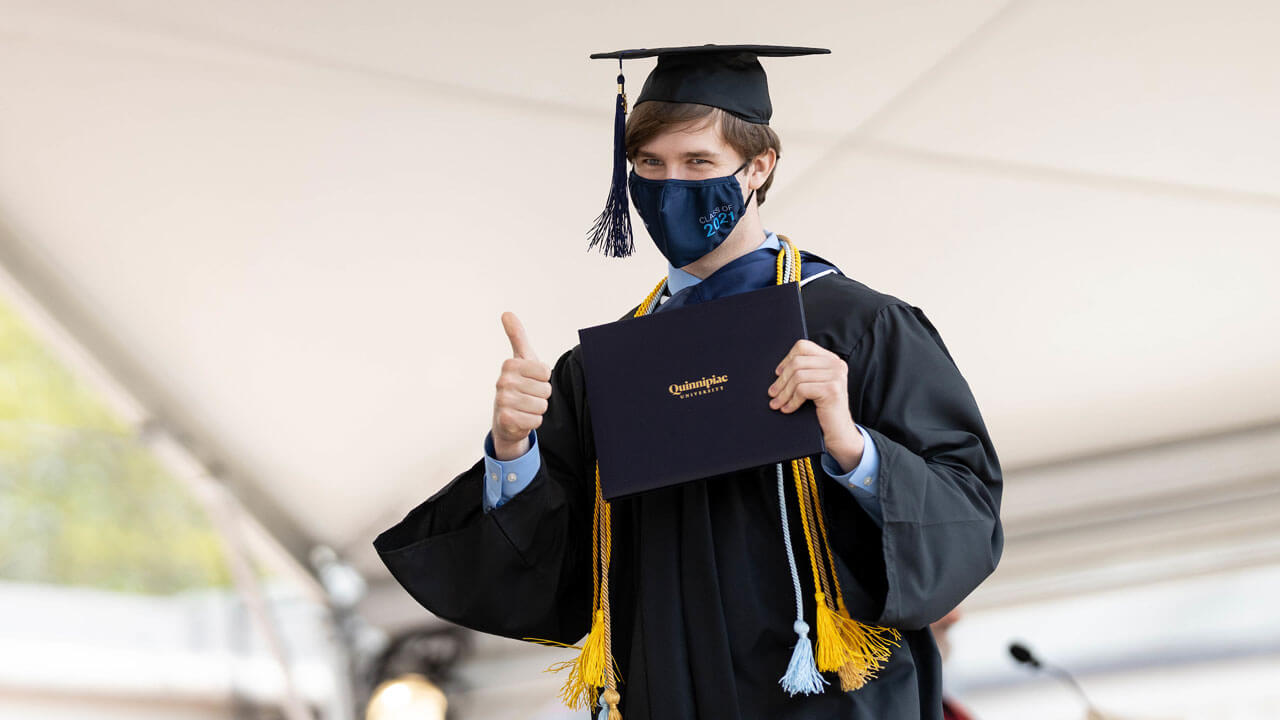 Student smiling and giving thumbs up