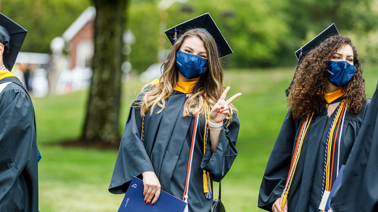 A graduate poses for a photo during the Commencement line up
