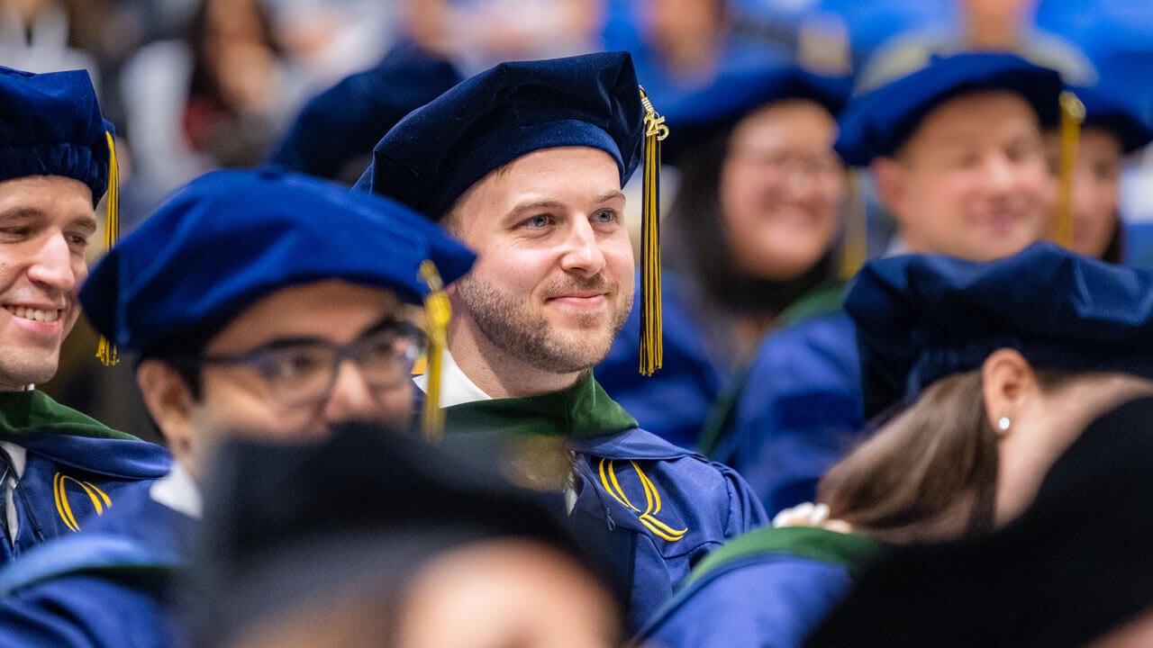 Graduate smiles while listening to speeches