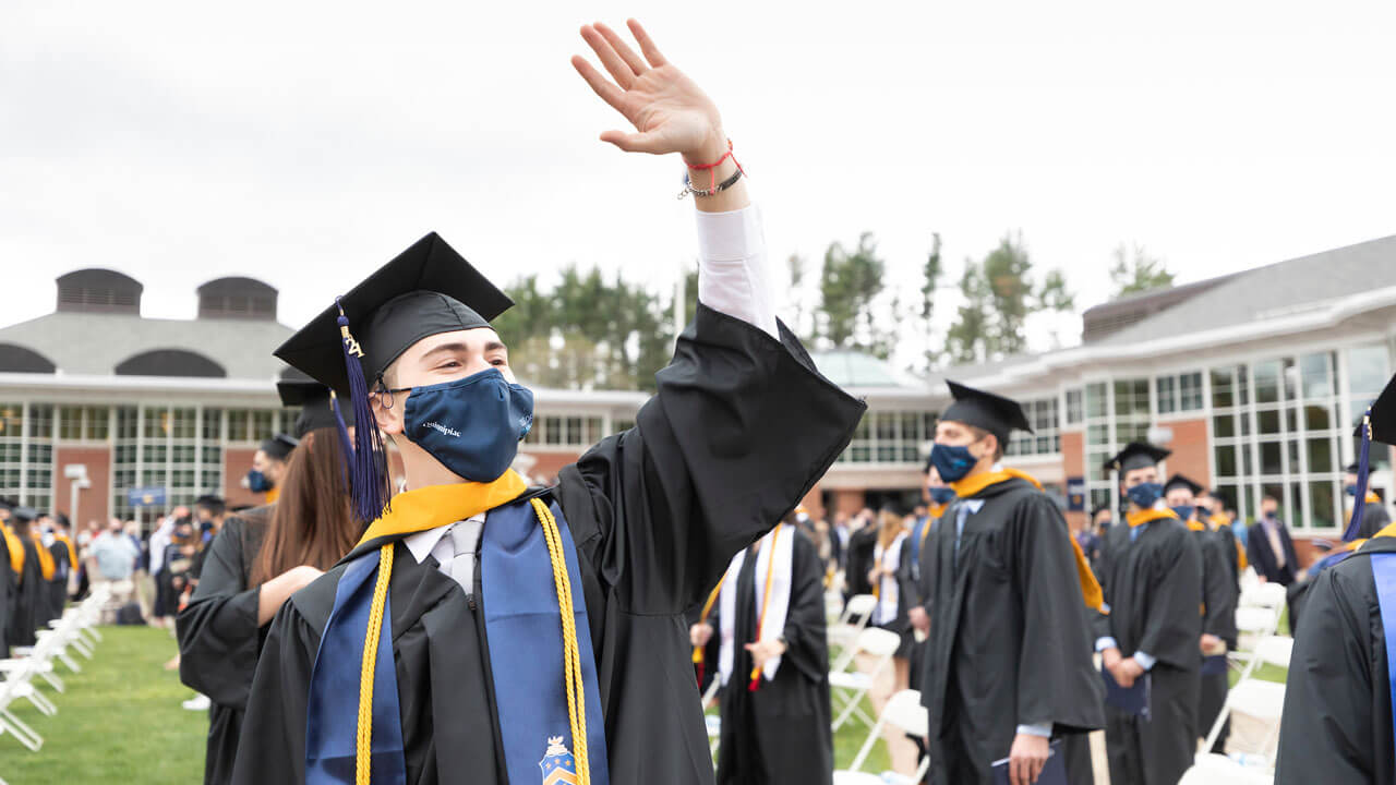 A graduate waves as he enters the Commecement ceremony