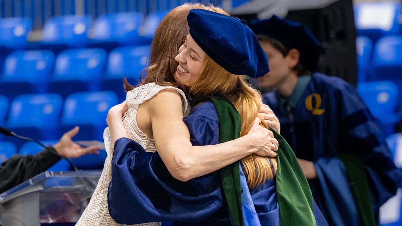 Guest hugs their student on stage.