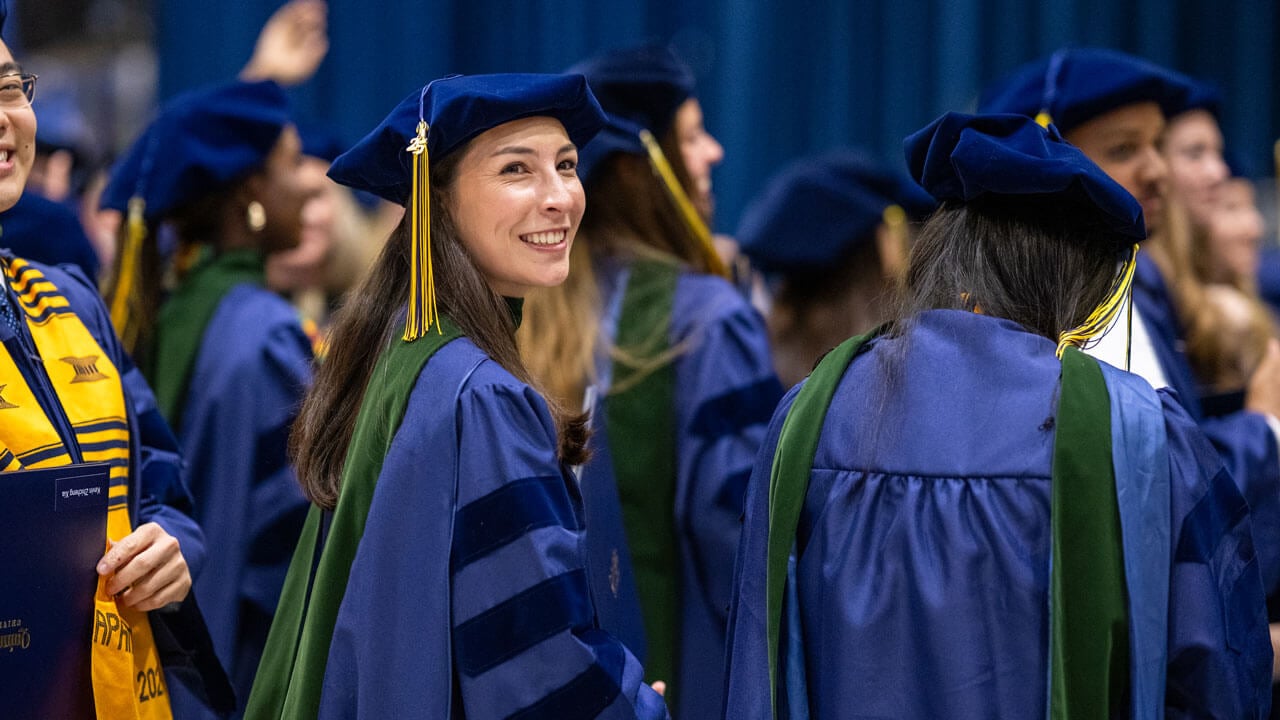 Graduate smiles while walking