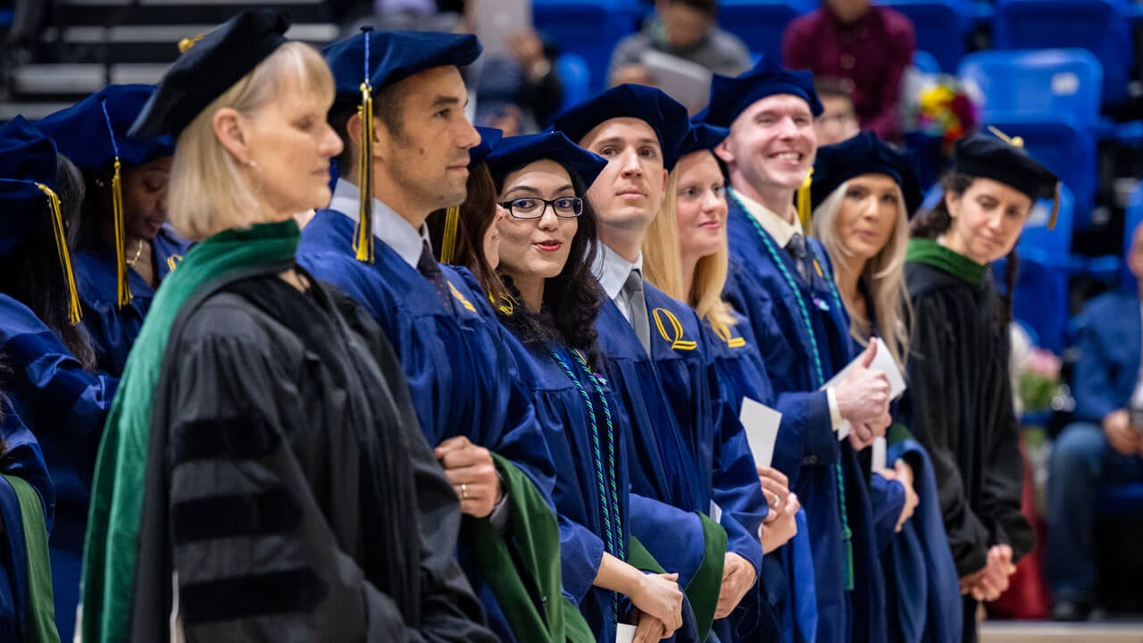 Graduates stand in a line during the commencement ceremony.