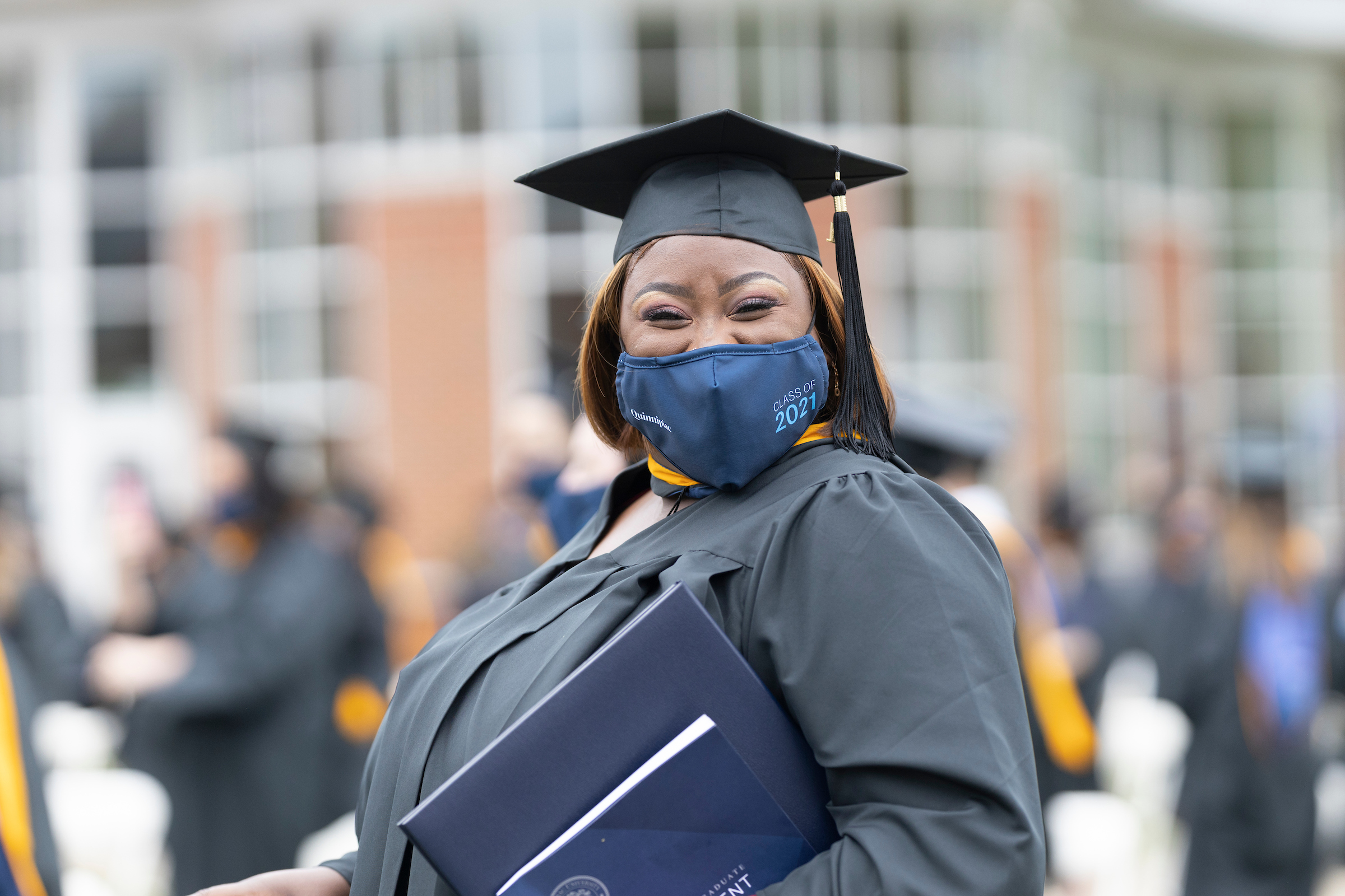 Student smiling while holding diploma
